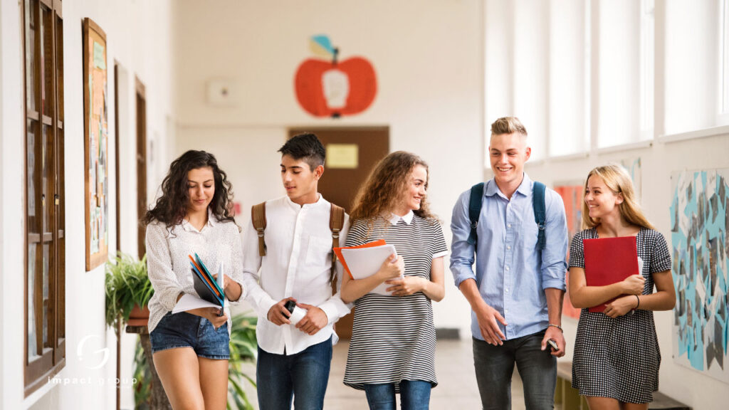 Students walking in a school hallway, discussing and holding notebooks, representing engagement strategies and professional development.