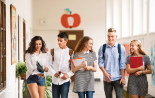 Students walking in a school hallway, discussing and holding notebooks, representing engagement strategies and professional development.